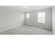 Bedroom with neutral carpet, walls, and two windows at 5006 Caspian St, St Cloud, FL 34771