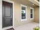 Welcoming front entryway with black door, neutral stucco, and trim at 5006 Caspian St, St Cloud, FL 34771