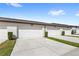 Row of attached garages with green space and driveways, and visible unit numbers under the eaves at 5006 Caspian St, St Cloud, FL 34771
