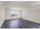 Bedroom with wood-look floors, large window offering natural light, and neutral walls at 5217 Marshelder St, Apopka, FL 32712