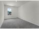 Bedroom with neutral carpet, a window providing natural light and minimal decor at 5217 Marshelder St, Apopka, FL 32712