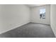 Bedroom featuring a gray carpet, white walls, and a window overlooking a green yard at 5217 Marshelder St, Apopka, FL 32712