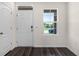 Bright entryway featuring a white front door, sidelight window, and wood-look flooring at 5217 Marshelder St, Apopka, FL 32712