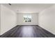 Open living room with dark wood-look flooring, bright natural light, and neutral paint at 5217 Marshelder St, Apopka, FL 32712