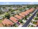 A high-angle view of residences showcasing tile roofs and proximity to a road and lush trees at 5337 Watervista Dr, Orlando, FL 32821