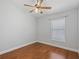 Clean bedroom featuring hardwood floors, white walls, a window, and a ceiling fan at 5337 Watervista Dr, Orlando, FL 32821