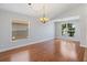 Empty dining room with hardwood floors, white walls, and a decorative chandelier fixture at 5337 Watervista Dr, Orlando, FL 32821