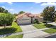 Charming single-story home featuring a two-car garage, beautiful landscaping, and a classic tile roof at 5337 Watervista Dr, Orlando, FL 32821