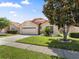 Attractive single-story home with a manicured lawn, shade tree, and a two-car garage at 5337 Watervista Dr, Orlando, FL 32821
