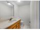 Bathroom with a sink, wood cabinets, toilet, and tiled floor at 6095 Village Cir # 6095, Orlando, FL 32822