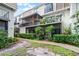 Back exterior view of condos with a bike on a balcony and lush landscaping at 6095 Village Cir # 6095, Orlando, FL 32822