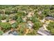 Aerial shot of homes in a leafy suburb, highlighting properties with private pools amidst a green canopy at 702 N Sweetwater Blvd, Longwood, FL 32779