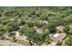 An aerial view of a lush residential neighborhood with mature trees and several homes featuring private pools at 702 N Sweetwater Blvd, Longwood, FL 32779
