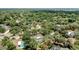 A suburban neighborhood from above showcasing houses nestled among dense trees, many with private swimming pools at 702 N Sweetwater Blvd, Longwood, FL 32779