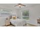 Bright bedroom featuring a cozy bed, soft lighting, and a large window with a garden view at 702 N Sweetwater Blvd, Longwood, FL 32779