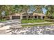 Beautiful single-story home with a spacious driveway, manicured lawn, and mature trees at 702 N Sweetwater Blvd, Longwood, FL 32779