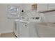 Functional laundry room equipped with modern washer, dryer, and sink for convenience at 702 N Sweetwater Blvd, Longwood, FL 32779