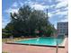 A community pool surrounded by lush trees, with a building visible in the background at 710 Ridenhour Cir # 710, Orlando, FL 32809