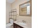 Bathroom featuring sink, vanity, toilet, and framed mirror with view into shower at 7449 Sugar Bend Dr # 7449, Orlando, FL 32819