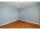 Empty bedroom with light blue walls, white trim, and hardwood floors at 7449 Sugar Bend Dr # 7449, Orlando, FL 32819