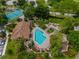 Aerial view of the community pool and clubhouse, surrounded by lush landscaping and palm trees at 7449 Sugar Bend Dr # 7449, Orlando, FL 32819
