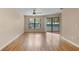 Bright living room features hardwood floors, a ceiling fan, and sliding door leading to a lanai at 7449 Sugar Bend Dr # 7449, Orlando, FL 32819