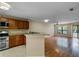 Open living space with hardwood floors, breakfast bar, and view into living room with outdoor access at 7449 Sugar Bend Dr # 7449, Orlando, FL 32819
