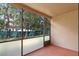 Screened porch with trees, greenery, and other buildings visible through the screen at 7449 Sugar Bend Dr # 7449, Orlando, FL 32819