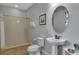 Bathroom featuring a walk-in shower, toilet, and pedestal sink with framed art on the walls at 7519 Marker Ave, Kissimmee, FL 34747