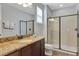 Bathroom featuring granite counters, dark wood cabinets and a glass enclosed shower at 7519 Marker Ave, Kissimmee, FL 34747