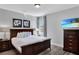 Bedroom featuring a queen bed, TV, light colored walls, and dark trim at 7519 Marker Ave, Kissimmee, FL 34747
