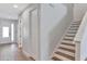 Hallway with a staircase and view of the front door, complemented by wood-look floors at 7519 Marker Ave, Kissimmee, FL 34747