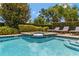 Swimming pool featuring an attached spa, privacy landscaping, and lounge chairs at 7519 Marker Ave, Kissimmee, FL 34747