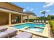 Backyard swimming pool featuring a spa, covered patio, privacy landscaping and lounge chairs at 7519 Marker Ave, Kissimmee, FL 34747