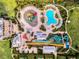 Aerial perspective of water park featuring multiple pools, slides, and play areas surrounded by tropical landscaping at 7643 Wilmington Loop, Kissimmee, FL 34747