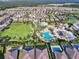 Aerial view of a community with a pool, splashpad, waterslides, a field, and many manicured green spaces at 7643 Wilmington Loop, Kissimmee, FL 34747