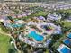 Aerial view highlighting a community pool, splashpad, waterslides, lounge chairs and manicured green spaces at 7643 Wilmington Loop, Kissimmee, FL 34747