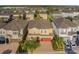 Aerial view of a beautiful two-story home showcasing the red garage doors and well-kept landscaping at 7643 Wilmington Loop, Kissimmee, FL 34747