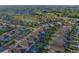 An aerial view displays a community with houses, swimming pools, a central pond and lush green spaces at 7643 Wilmington Loop, Kissimmee, FL 34747