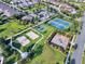 Aerial view of community featuring a beach volleyball court, tennis courts, park, and green spaces at 7643 Wilmington Loop, Kissimmee, FL 34747