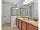 Elegant bathroom features a glass-enclosed shower and double vanity with granite countertops at 7643 Wilmington Loop, Kissimmee, FL 34747