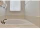 Bright bathroom with a soaking tub, white tiles, and modern fixtures at 7643 Wilmington Loop, Kissimmee, FL 34747
