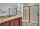Bathroom featuring granite countertops, wood cabinet vanity, and a glass-enclosed shower at 7643 Wilmington Loop, Kissimmee, FL 34747