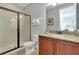 Bathroom features a shower with glass door, granite countertop vanity, and framed mirror at 7643 Wilmington Loop, Kissimmee, FL 34747