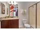 Bathroom featuring granite countertops, a wood cabinet vanity, and a glass-enclosed shower at 7643 Wilmington Loop, Kissimmee, FL 34747