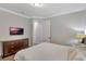 Bright bedroom features a mounted TV, wood floors, and ensuite bathroom access at 7643 Wilmington Loop, Kissimmee, FL 34747