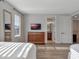 Bedroom with hard wood floors featuring a dresser, tv, and a large window for natural light at 7643 Wilmington Loop, Kissimmee, FL 34747