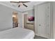 Bright bedroom featuring a mounted TV, wood floors, and ensuite bathroom access at 7643 Wilmington Loop, Kissimmee, FL 34747
