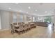 Open floorplan with tile floors features a long dining room table that joins to the main living room at 7643 Wilmington Loop, Kissimmee, FL 34747