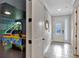 Hallway featuring an arcade game room, tile floors, and a front door with glass panels at 7643 Wilmington Loop, Kissimmee, FL 34747
